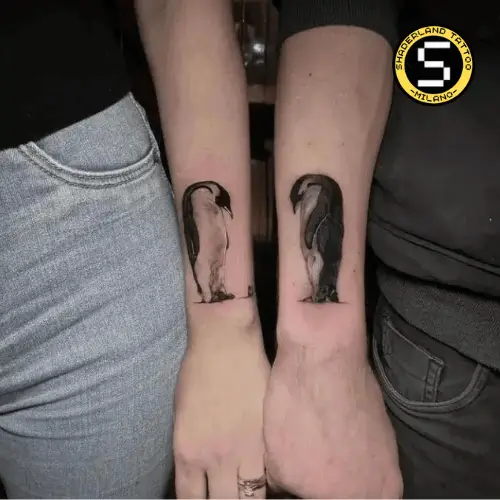 tatuaggi di due pinguini avambraccio esterno in realistico